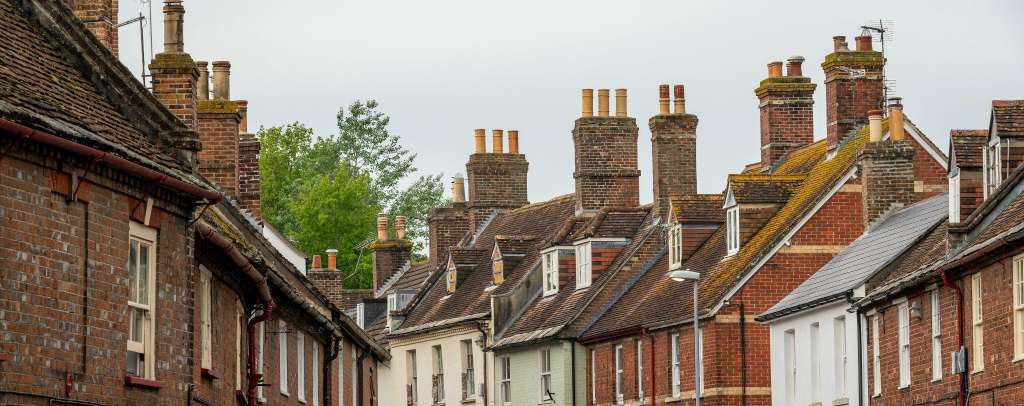 Traditional brick terraced houses in Cambridgeshire with multiple chimney stacks showing typical properties at risk of hidden chimney blockage dangers requiring professional safety inspection