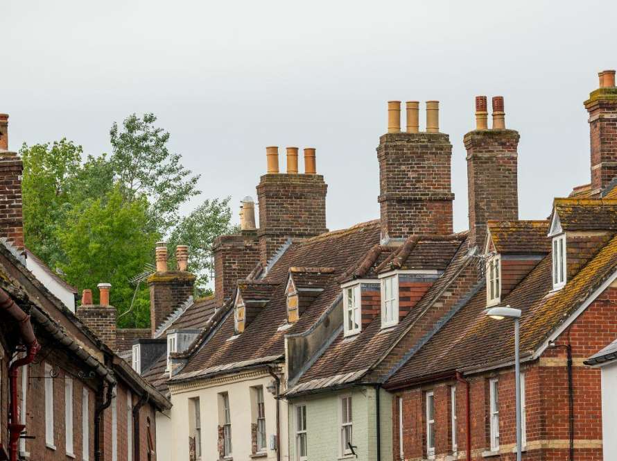 Traditional brick terraced houses in Cambridgeshire with multiple chimney stacks showing typical properties at risk of hidden chimney blockage dangers requiring professional safety inspection