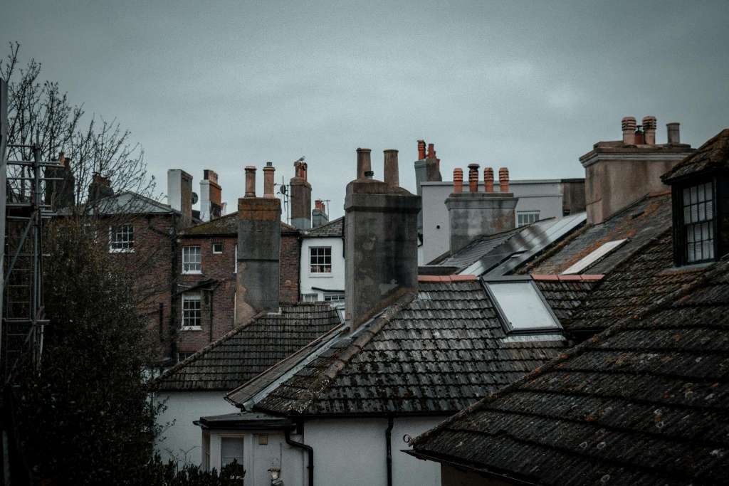 Multiple chimney stacks across Cambridge rooftops showing variety of properties that may benefit from professional chimney cowl assessment for downdraught and performance issues