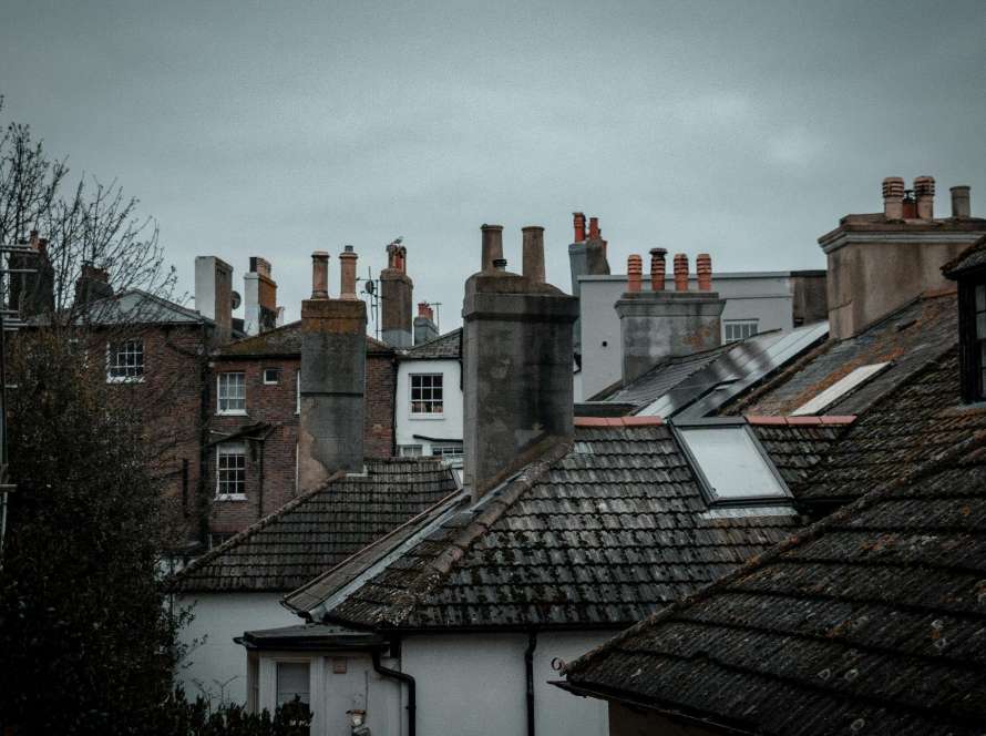 Multiple chimney stacks across Cambridge rooftops showing variety of properties that may benefit from professional chimney cowl assessment for downdraught and performance issues