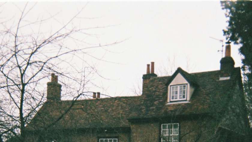 Traditional Cambridge area stone cottage with multiple brick chimney stacks, showing typical property where professional chimney sweeping improves heating efficiency and reduces energy bills
