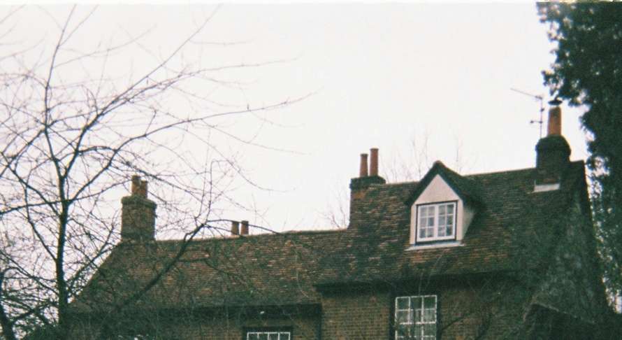 Traditional Cambridge area stone cottage with multiple brick chimney stacks, showing typical property where professional chimney sweeping improves heating efficiency and reduces energy bills