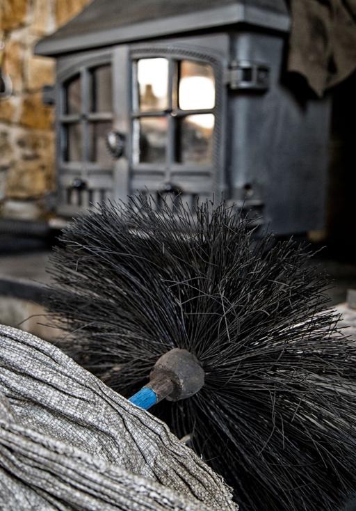 Professional chimney cleaning brush for wood burning stove flue maintenance, demonstrating essential professional services for autumn preparation