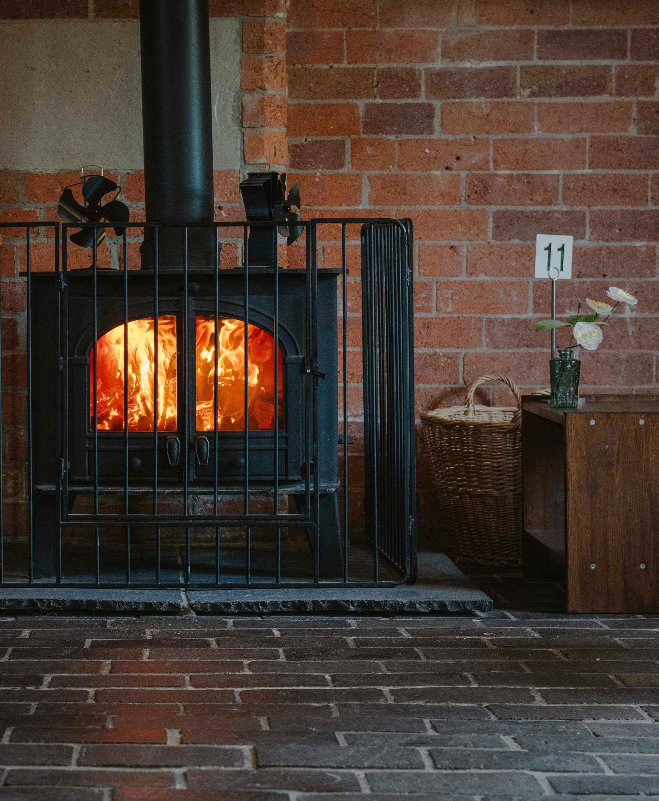 Homeowner performing summer stove care by cleaning ash from a wood burning stove