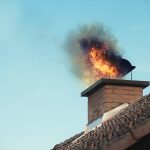 Chimney fire with flames and smoke coming from a chimney pot